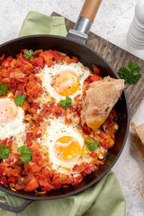 Shakshouka, eggs poached in sauce of tomatoes,