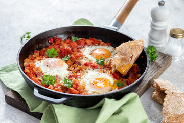 Shakshouka, eggs poached in sauce of tomatoes,