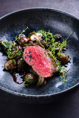 Modern style traditional fried dry aged angus beef filet medaillons natural with mushrooms and...