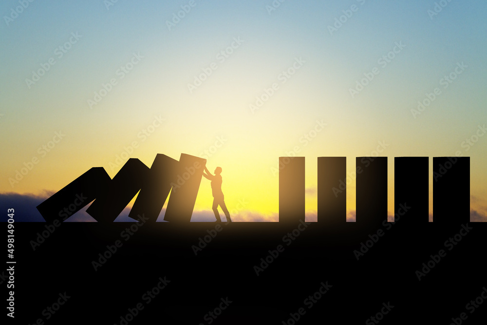Poster backlit business man stopping abstract wooden domino blocks on bright sunset sky background with moc