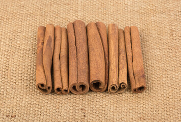a lot of cinnamon sticks on a background of burlap