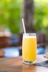 Glass with freshly squeezed orange juice in cafe at tropical resort