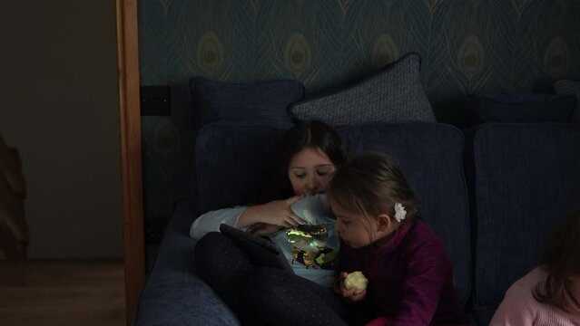 authentic 3 little preschool toddler minor children kids siblings watch cartoon playing games online chating on smartphone device laptop tablet together at home indoors. Family, childhood, friendship