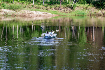 Obraz na płótnie Canvas kayak crew sails away into the distance on the river