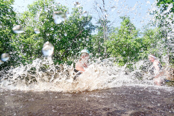 The girl is having fun in the river with splashes