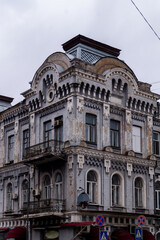 Fototapeta na wymiar Facade with balconies of the old house in city in cloudy day. Old building with balcony