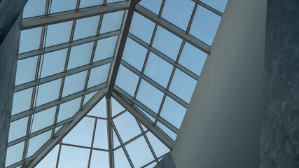 Triangle glass roof in a mall. Glass triangle glass roof and clear sky