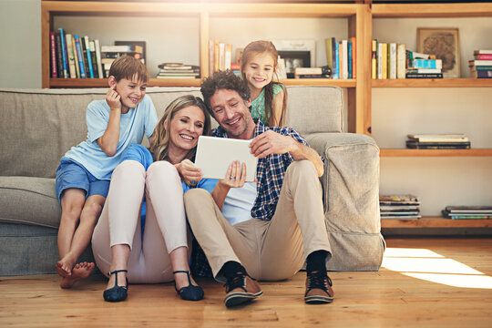 The Connected Family Is A Happy Family. Shot Of A Happy Family Using A Digital Tablet Together At Home.