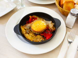 traditional spanish goat cheese with vegetables served in cast iron pan
