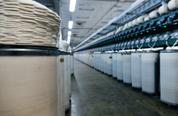 Fototapeta premium Large round containers with industrial cotton thread twisted in a spiral