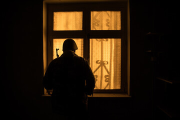 Conceptual photo of war between Russia and Ukraine. Ukraine and Russia flags on windowsill at night. Old creepy room with window.