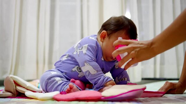 baby latina girl sitting in her natural state grabbing the first thing she sees. 4k video