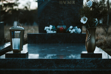 Laterne und Blumen auf einem Grab