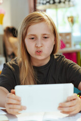 child in grey shirt distance learning at home in sunny day © Alliance