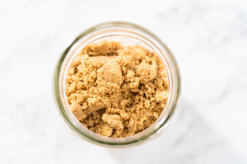 Light brown sugar in a glass container.