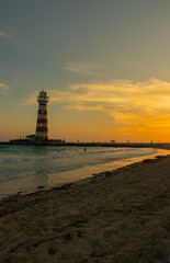 Fototapeta premium Sunset on paradise island with trees and clouds in the sky with lighthouse.