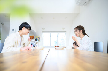 Fototapeta premium リビングダイニングでご飯を食べる夫婦 広角 前ボケあり