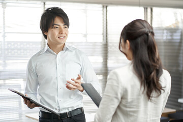 仕事の手順を説明するアジア人ビジネスパーソン