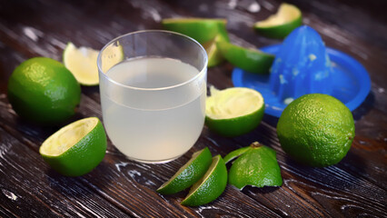 Lime fresh in a glass. Fresh limes. Juicer.