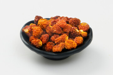 Black Bowl of Dried Golden Berries Isolated on a White Background. (Physalis peruviana)