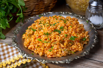 Traditional turkish bulgur pilaf with tomato sause in plate (Turkish name; meyhane pilavi)
