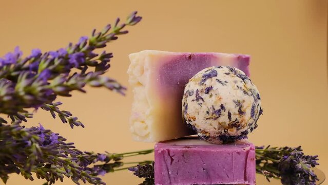 Lavender soap and bath truffles, lavender branches on a beige background. 4k footage