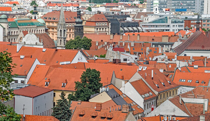 Fototapeta na wymiar Towers and steeples pop up among the red tile rooftops of Bratislava, Slovakia.