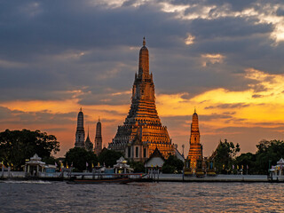 Naklejka premium Wat Arun is a temple next to the river and is a unique temple. In beautiful Thai art and with a beautiful sky with clouds in the background and evening light located in Bangkok, Thailand.