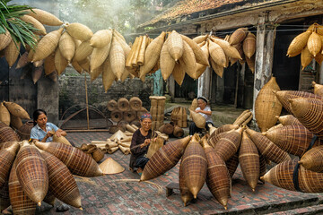 Group of Old Vietnamese female craftsman making the traditional bamboo fish trap or weave at the old traditional house in Thu sy trade village, Hung Yen,Vietnam, traditional artist concept