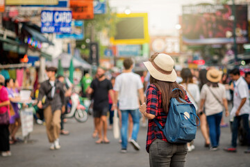 Back side of Young Asian traveling women walking and looking in Khaosan Road walking street in evening at Bangkok, Thailand, traveler and tourist concept