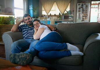Obraz premium Soon well be a family. Shot of a loving pregnant couple relaxing on the couch together at home.