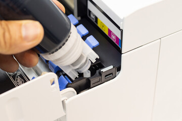 Technicians are installing setup the ink and Insert ink into the fill hole. of an inkjet printer,...