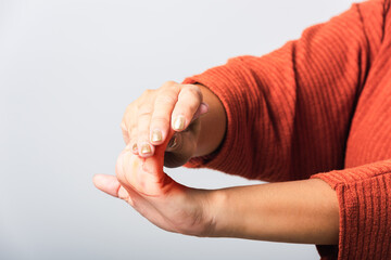 Close up hand of Asian woman she holding her acute pain in wrist of hands, studio shot isolated on white background, Healthcare medicine arthritis body care symptomatic office syndrome concept