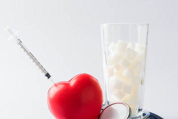 A glass full of white sugar cube sweet food ingredient and doctor stethoscope, studio shot isolated...