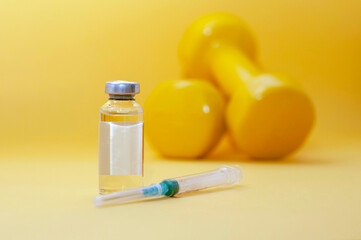 syringe lies next to a jar of liquid and dumbbells on a yellow background, horizontal picture, copy space. the concept of doping in sports, steroids, testosterone and other drugs banned in sports.
