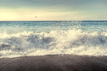 Waves splashing over the shore at sunset