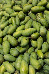 Ripe mangoes or mangos in a market in bright sun. Vertical 