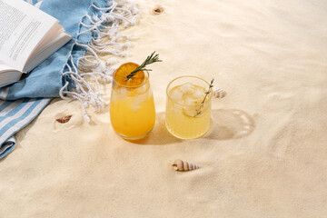 Selection of summer alcoholic cocktails on a wicker tray on beach with white sand. Summer sea...