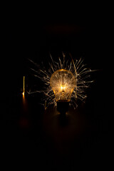 Incandescent lamp with sparks on a black background.