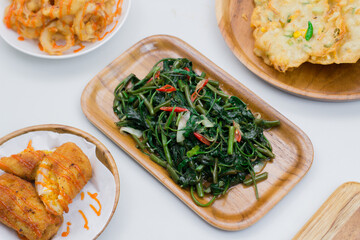 Processed kale. Served on a wooden plate. Cah Kangkung.