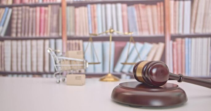 Consumer rights and protection, business law concept : Wooden judge gavel, a shopping cart, a balanced scale of justice on a table, depicting the practice of safeguarding buyers of goods and services.