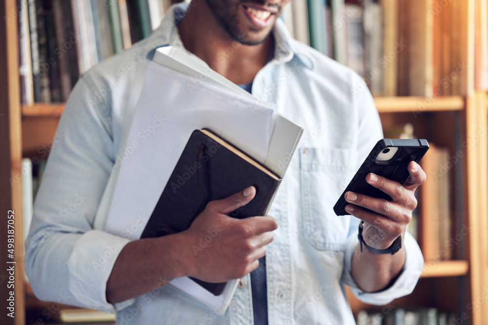 Poster The smartest student on campus. Shot of a man using a smartphone in a library at university.