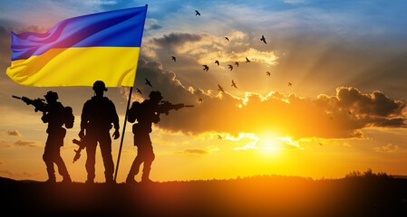 Flag of Ukraine with silhouette of soldier against the sunrise or sunset. Concept - armed forces of...