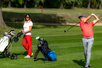 Obraz premium Smiling golfing couple enjoying a game of golf