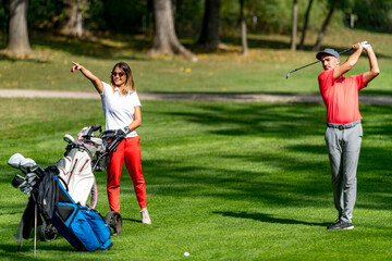 Young couple playing golf on a beautiful summer day