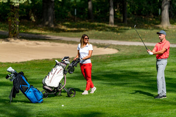 Young couple playing golf on a beautiful summer day