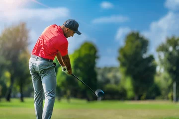 Fototapeten Pro golfer in a golf swing, using a driver golf club, rear view © Microgen