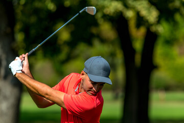 Powerful golf swing. Young golfing professional in golf swing