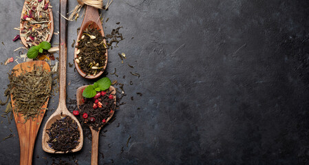 Various dried tea in wooden spoons