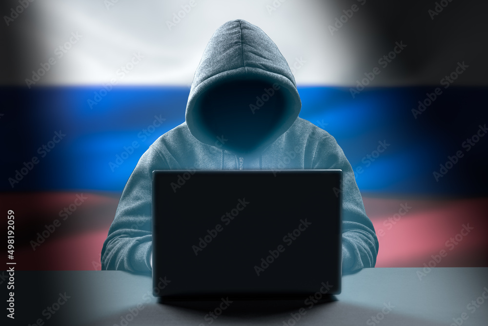 Poster faceless hooded anonymous russian hacker on russian flag background. anonymous person in hood sittin